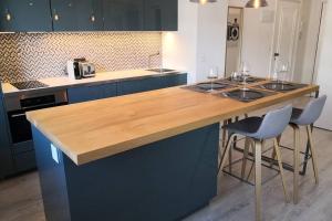 a kitchen with blue cabinets and a wooden counter top at Apto con vistas a BAHÍA DE PASAJES, a 10 min del centro de San Sebastián in Lezo