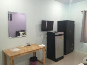 a room with a refrigerator and a wooden table at Maehaad Guesthouse in Mae Haad