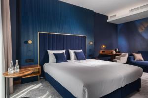 Un dormitorio con una cama grande y una pared azul. en My Story Gdynia Hotel, en Gdynia