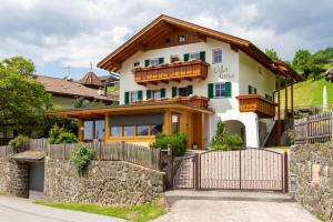 a house with a stone fence in front of it at Villa Anna in Siusi