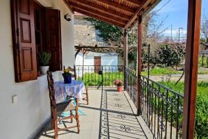 eine Terrasse mit einem Tisch und Stühlen auf dem Balkon in der Unterkunft Feli's country house in Argalasti