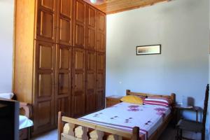 Schlafzimmer mit einem Bett und einem Holzschrank in der Unterkunft Feli's country house in Argalasti