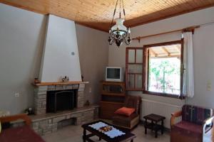 a living room with a fireplace and a tv at Feli's country house in Argalasti