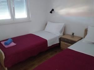 1 Schlafzimmer mit 2 Betten und einem Fenster in der Unterkunft Apartmani Petra in Olib