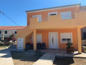 a large orange house with two white doors at Apartmani Petra in Olib