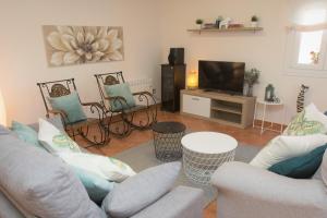 ein Wohnzimmer mit Sofa und Fernseher in der Unterkunft Hospedium Galitrips Vila Maruja Corme in Corme-Puerto