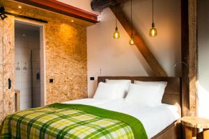 een slaapkamer met een bed met een groene deken bij B&B Grevenberg in Oosterhesselen