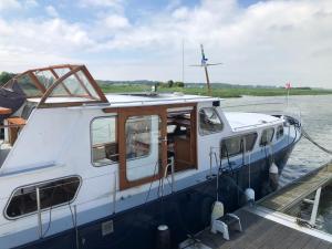 een boot is aangemeerd op een dok in het water bij La Vedette Hollandaise in Étaples