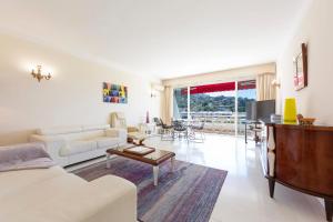 uma sala de estar com um sofá e uma mesa em Fully equipped appartment 105 m2 clear view on the sea and californie hills em Cannes