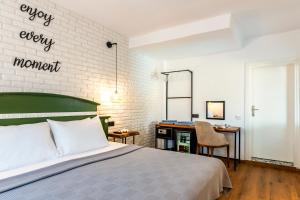 a bedroom with a bed and a desk with a mirror at The Poyz Hotel Bodrum in Gümbet