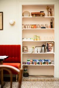 a book shelf with food and a red chair at Maison Séraphine - Guest house - Bed and Breakfast in Laon
