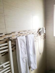 bagno con asciugamani bianchi appesi a un appendiabiti di Sport Avalanche a Ranca
