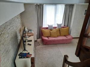 sala de estar con sofá rosa y almohadas amarillas en Ioana Hotel, en Sinaia