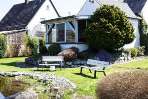 two benches sitting in the grass in front of a house at Haus Pia - Monteur Haus in Bubesheim