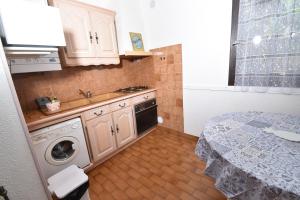 a small kitchen with a sink and a washing machine at Maison de vacances Grau du roi in Le Grau-du-Roi