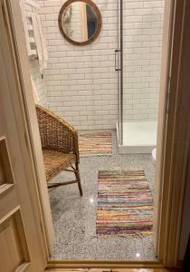 a bathroom with a shower with a bench and a mirror at Apartament w starej kamienicy w Reszlu in Reszel