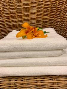 a stack of white towels with a flower on top at Apartament w starej kamienicy w Reszlu in Reszel
