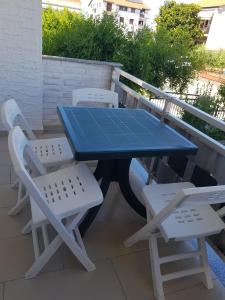 een blauwe tafel en twee witte stoelen op een terras bij Hana in Umag