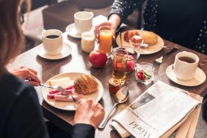 una mujer sentada en una mesa con platos de comida en Le Grand Hotel en Estrasburgo