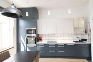 a kitchen with blue and white cabinets and a table at Nordic Host - Frogner - Well appointed 2 Bedroom in Lovely West Side Neighborhood in Oslo