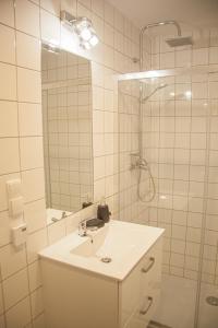 uma casa de banho branca com um lavatório e um chuveiro em Przytulny Apartament Mickiewicza 14 4 em Wieleń