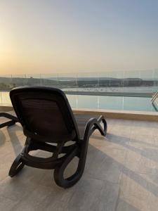 a black chair sitting in front of a window at Hotel VIU57 in Mellieħa