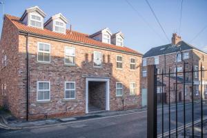 a brick building with a door on a street at Penleys Apartment in York +28 photos