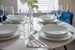 uma mesa com pratos e copos de vinho em Penleys Apartment em York