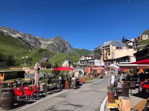 uma rua com mesas e cadeiras e uma montanha em La Mongie - Au pied des pistes 1 et 2 Parking souterrain em La Mongie