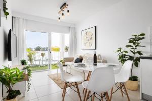 un soggiorno bianco con tavolo e sedie bianchi di Lanzarote Blue Senator a Costa Teguise