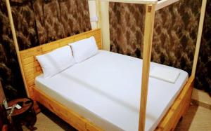 a bed with two white pillows on it at KimyaKimya Pub & Lodge in Dar es Salaam