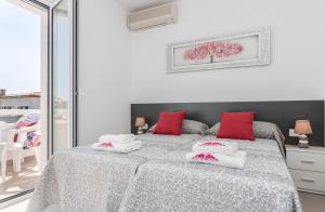 エンプリアブラバにあるApart-rent Apartment Bahia 0014のベッドルーム1室(赤い枕のベッド1台付)