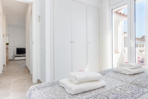 エンプリアブラバにあるApart-rent Apartment Bahia 0014の白いベッドルーム(白い枕2つ付)