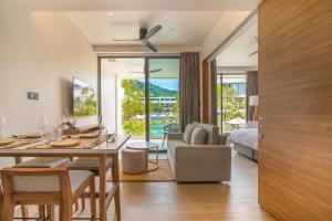 a living room with a dining table and a bedroom at Stay Wellbeing & Lifestyle Resort in Rawai Beach