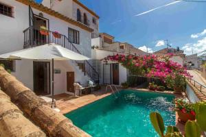 a swimming pool in front of a house with flowers at Casa con piscina Gades-Marisol in Altea