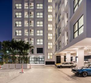 a large building with cars parked in a parking lot at Siamplaengna Residence in Bangkok