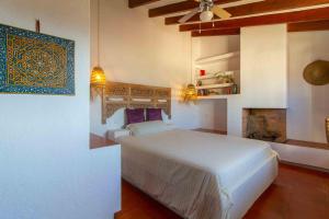 a bedroom with a white bed and a fireplace at Casa con piscina Gades-Marisol in Altea +17 photos