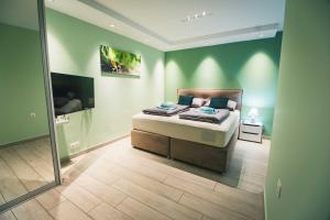 1 dormitorio con 1 cama en una habitación con paredes verdes en The Place Apartments Hebrangova, en Zagreb