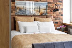sypialnia z łóżkiem z ceglaną ścianą w obiekcie Apartamenty Efekt 72 w mieście Gdynia