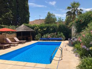 a swimming pool in a backyard with a garden at Maison Oleander in Bize-Minervois