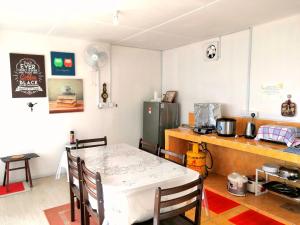 a small kitchen with a table and a refrigerator at D' Limbai Cottage in Ranau