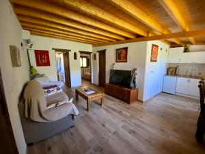 a living room with a couch and a tv at Las Palmeras Temisas in Temisas