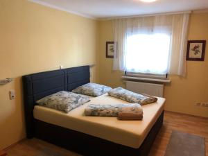 um quarto com uma cama com duas almofadas e uma janela em Ferienhaus Gonsbach em Mainz