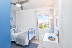 a white bedroom with a bed and a window at Casa Montserrat in Los Llanos de Aridane