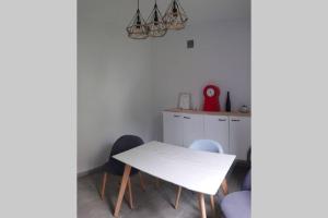 een eetkamer met een witte tafel en stoelen bij Le BEauséjour - Cosy T2 - Business ou we - gare in Bellegarde-sur-Valserine