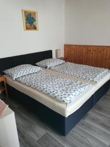 Schlafzimmer mit einem großen Bett mit einem Kopfteil aus Holz in der Unterkunft Ubytování Maxa in Špičák