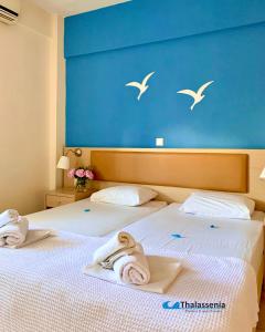 Dos camas en una habitación de hotel con toallas. en Thalassenia Studios en Chanioti