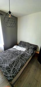 a bed with a black and white comforter in a bedroom at JUNA2 - nowoczesny apartament w centrum z widokiem na park in Pruszków