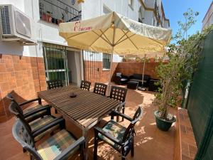 een houten tafel en stoelen met een parasol op een patio bij Apartamento en el centro de Estepona in Estepona