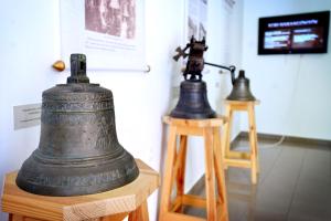 Eine alte Glocke auf einem Stand neben einer Kamera in der Unterkunft Servita Udvarház Eger in Eger